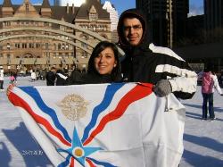 Assyrian flag held-up by a couple in Canada