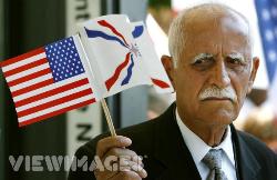 Assyrian flag held high by an elderly Assyrian man in USA